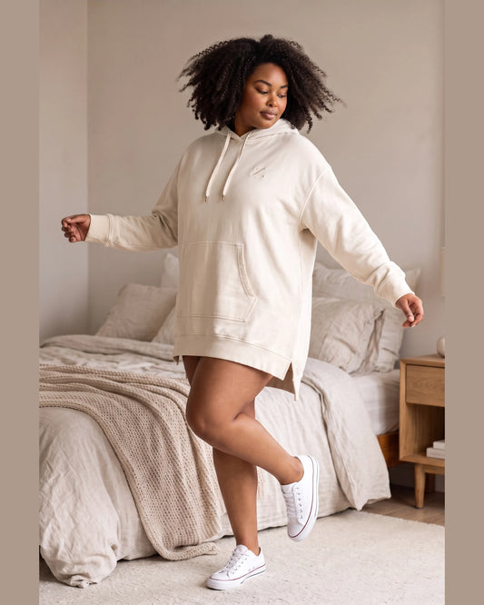 Indoor lifestyle view of oversized hoodie dress with hood down