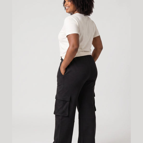 Back and side view of black Legacy cargo pants showing relaxed wide-leg fit and cargo pocket construction.