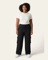 Front view of woman wearing black Legacy 450 GSM cargo pants with elastic drawcord waist and utility pockets.