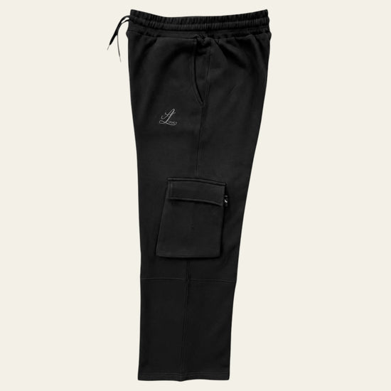 Side view of black Legacy cargo pants showing thigh flap pocket, panel seam and relaxed straight leg.